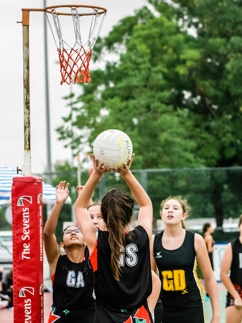 Girl shooting a netball at the Sevens